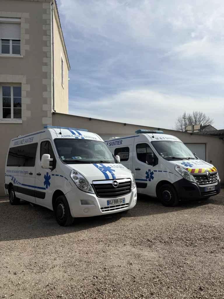 Véhicules d'ambulance et de transport sanitaire stationnés en extérieur.