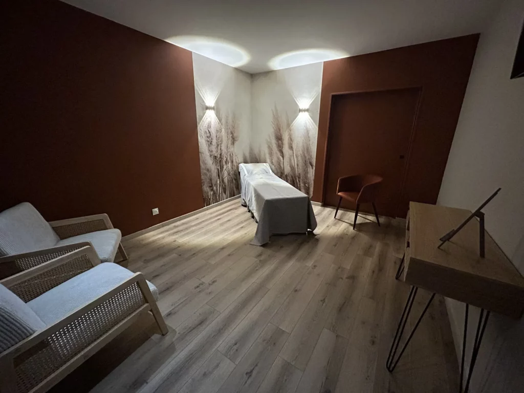Chambre funéraire moderne aux tons terracotta avec lit de repos et fauteuils.