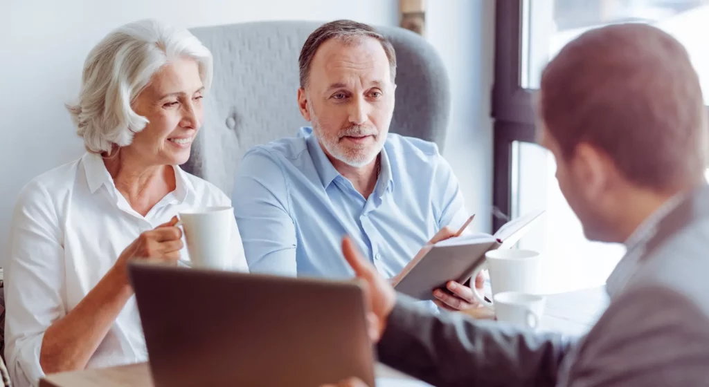 Couple senior en rendez-vous avec un conseiller pour un contrat d'obsèques.